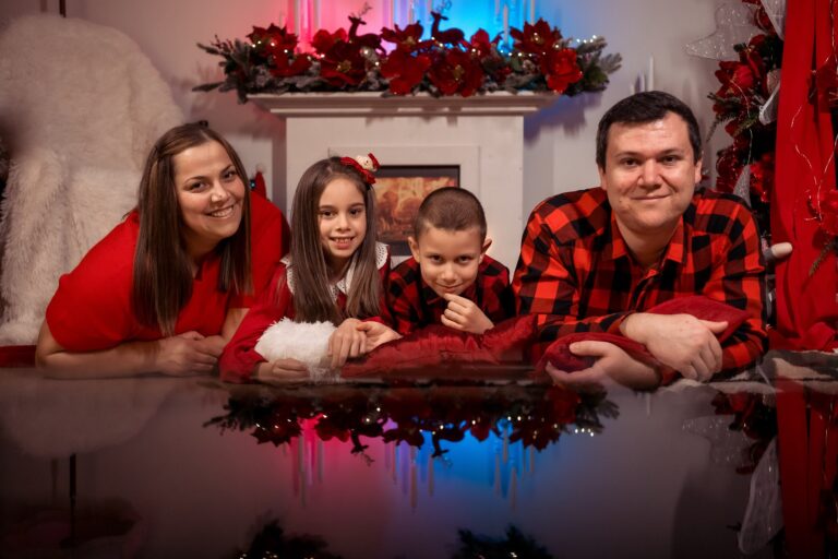 Familie cu copii lângă șemineu de Crăciun