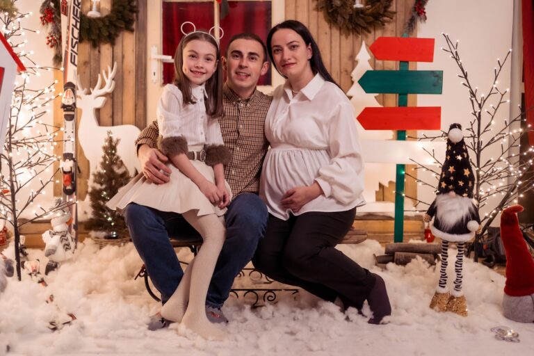Familie care așteaptă un bebeluș, decor de Crăciun