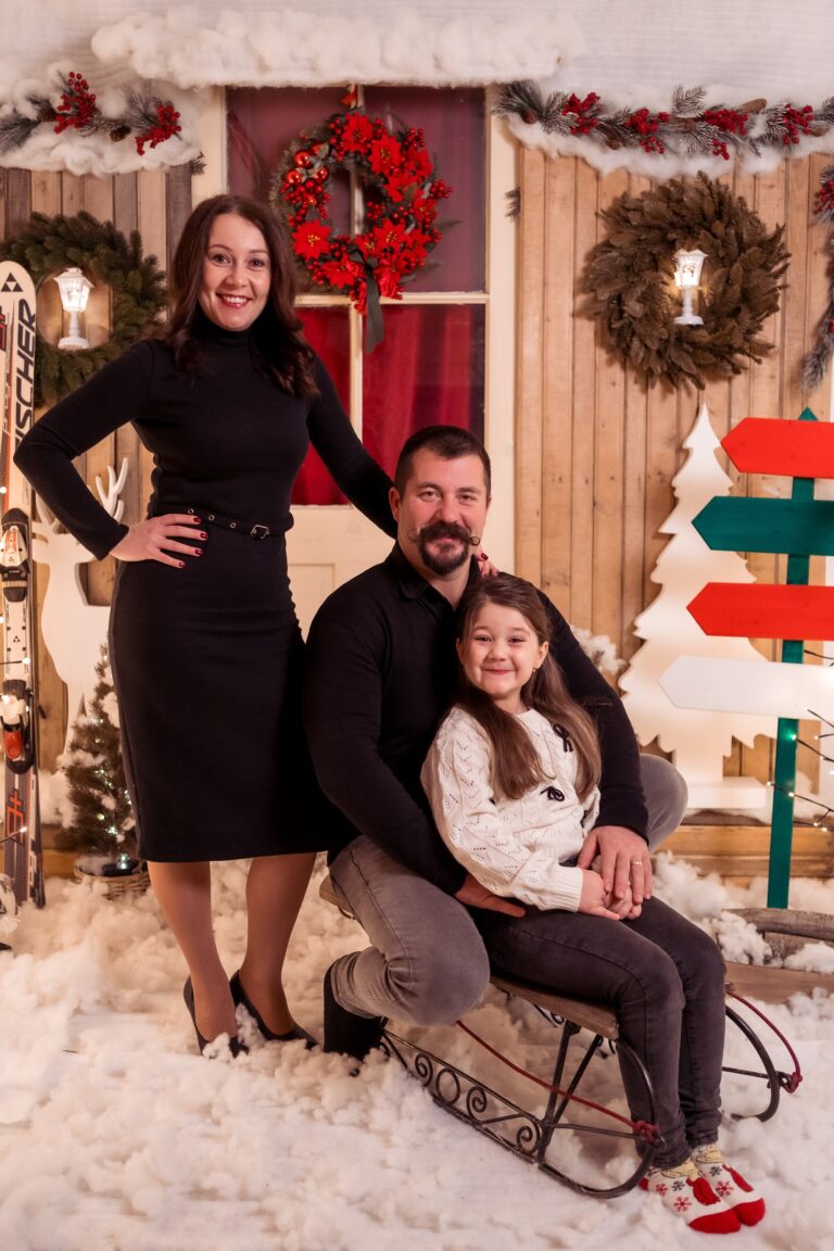 Familie pe sanie în decorul de Crăciun